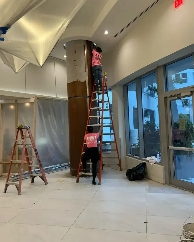 Ligio's Solutions crew on ladders finishing a lobby column