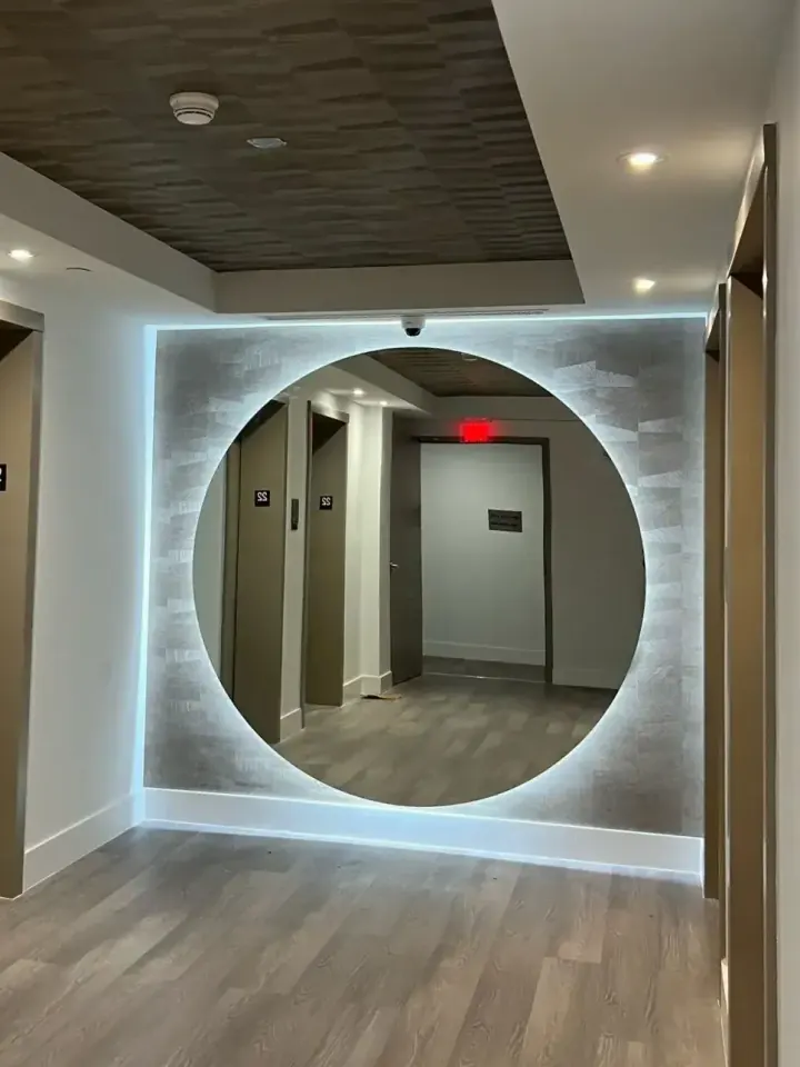 Elevator lobby with the new circular backlit mirror, renovated by Ligio's Solutions in Hollywood, FL